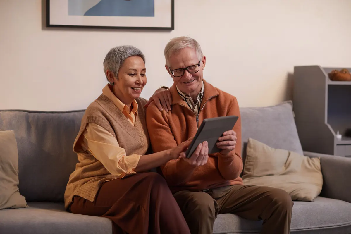 A family member helping an older adult set up games on a tablet