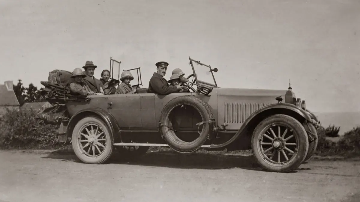 A family ready to play screen-free road-trip games in a vintage car