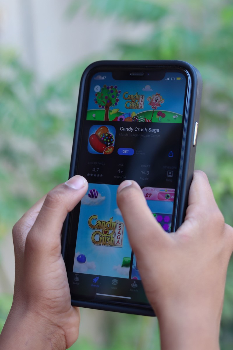 Hands playing a classic-style mobile game on a phone