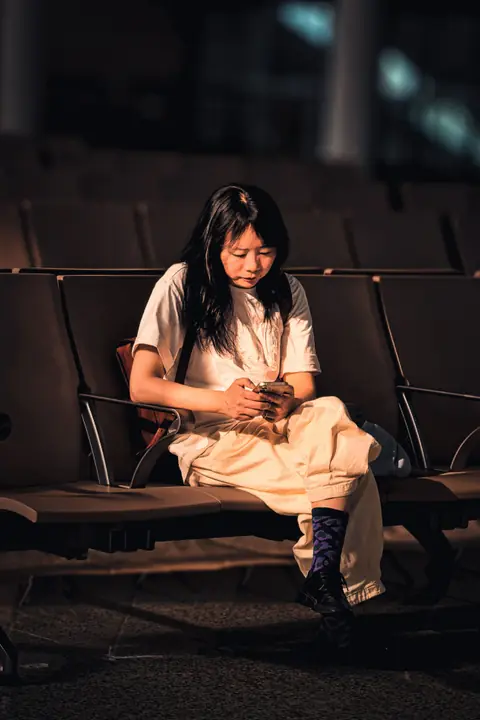 Traveller using no WiFi games while waiting in a quiet airport terminal