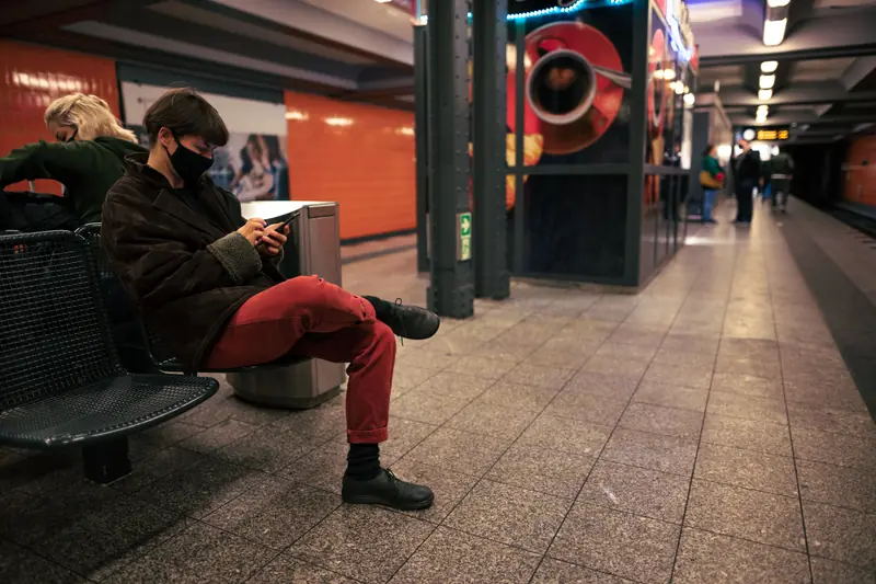 Passenger using a phone while waiting at a subway station
