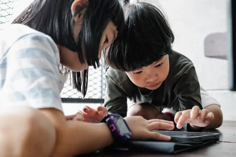 Children testing a tablet before taking offline games on a road trip