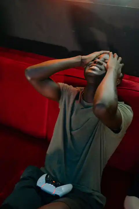 Frustrated player holding a phone while considering a pay-to-win game