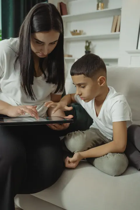 A parent and child choosing safe iOS games together on a tablet